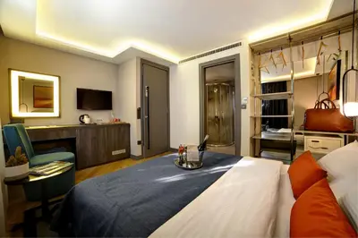 a hotel room with a bed and a living room at The Capital Suites in Istanbul