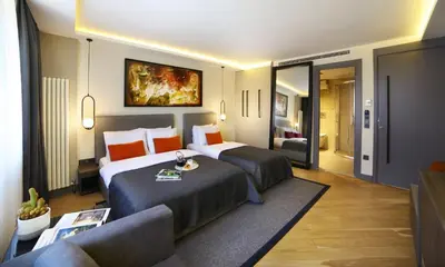 a hotel room with two beds and a couch at The Capital Suites in Istanbul