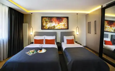 a hotel room with two beds and a tray of food at The Capital Suites in Istanbul