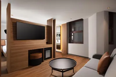 a living room with a couch and a television on a wall at Moxy Istanbul Taksim in Istanbul