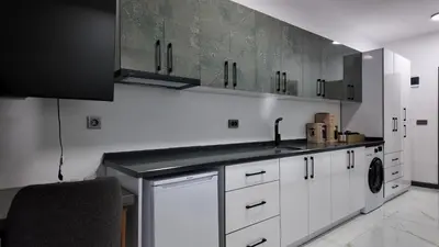 a kitchen with white cabinets and a sink and a dishwasher at farazarooms in Serdivan