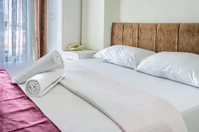 a bed with white sheets and towels on it at Hotel yeniçiftlik in Yeniçiftlik