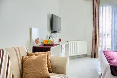 a living room with a couch and a tv at Hotel yeniçiftlik in Yeniçiftlik