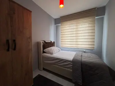 a bedroom with a bed and a window with blinds at Zeus Suit Görükle in Nilüfer