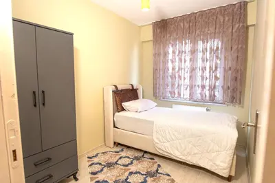 a small bedroom with a bed and a window at Zeus Suit Görükle in Nilüfer