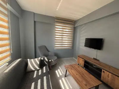 a living room with a couch and a tv at Zeus Suit Görükle in Nilüfer