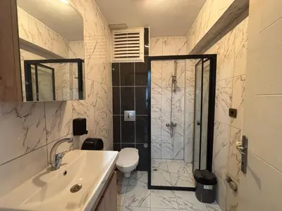 a bathroom with a shower and a toilet and a sink at Zeus Suit Görükle in Nilüfer