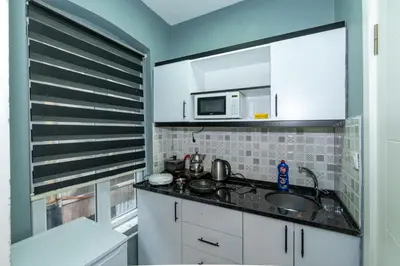 a kitchen with a sink and a microwave at rest at home in Istanbul