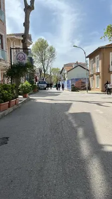 a street in a town with people walking down the street at Palmiye Pansiyon in Adalar