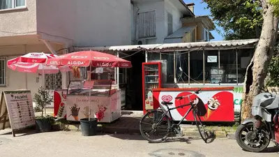 a bike parked next to a food cart with an umbrella at Palmiye Pansiyon in Adalar