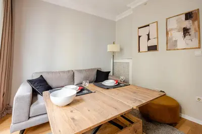 a living room with a wooden table and a couch at Raya Cihangir Suites in Istanbul