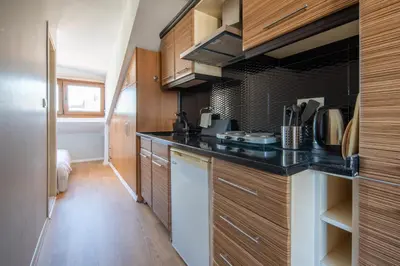 a kitchen with wooden cabinets and a black counter top at Raya Cihangir Suites in Istanbul