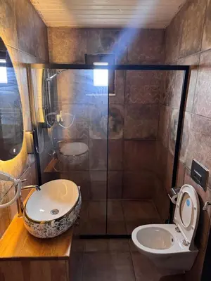 a bathroom with a shower and a toilet and a sink at Keyfe Kadir Garden Butik Otel in Orhangazi