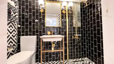 a bathroom with a black and white tiled wall at Loft Black Sapanca in Sapanca