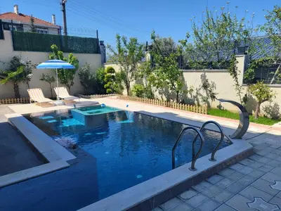 a swimming pool with two chairs and an umbrella at Comfort 4 bedroom villa yalova see view in Termal