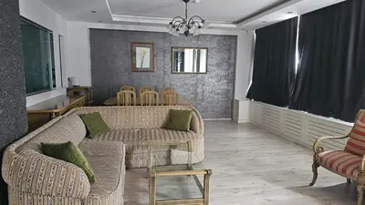a living room with two couches and a table and chairs at City Center Suite in Istanbul