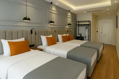 two beds in a hotel room with orange and gray at Center Port Hotel Karaköy in Istanbul
