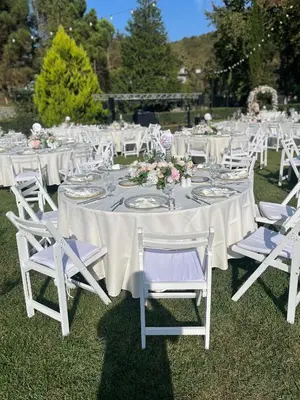 a table set up for a wedding with white tables and chairs at Villa Riva Garden in Polonezkoy