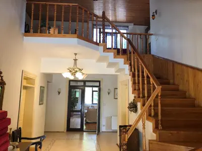 a staircase in a living room with a chandelier at Villa Riva Garden in Polonezkoy