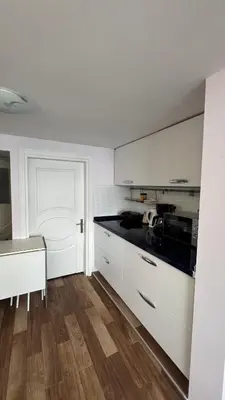 a kitchen with white cabinets and a black counter top at Deluxe Duplex in city center with 210 degrees Bosphorus viewed in Istanbul