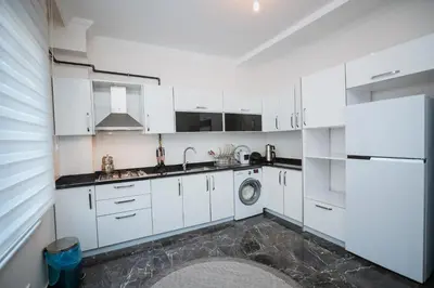 a white kitchen with a sink and a dishwasher at One Suit in Kartepe