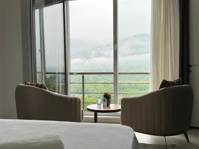a bedroom with a bed and two chairs and a table at One Suit in Kartepe