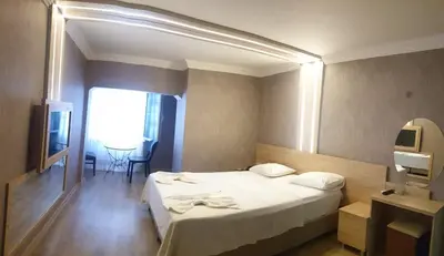 a hotel room with a large bed and a table at City Light Otel in Istanbul