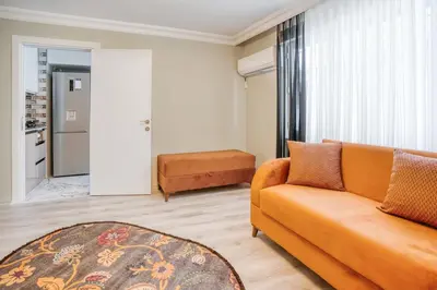 a living room with an orange couch and a kitchen at SULTANAHMET oldcity nice suite in Istanbul
