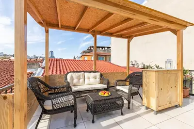 a patio with chairs and a couch on a roof at Maison Istanbulite in Istanbul