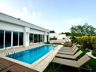 a swimming pool with lounge chairs and a house at Sakarya Sapanca Memnuniye de 2 oda 1 salon Özel Havuzlu , Muhafazakar , Şömineli , Jakuzili 6 Kişilik Tatil Villası in Sapanca