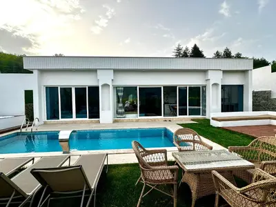 a backyard with a pool and chairs and a table at Sakarya Sapanca Memnuniye de 2 oda 1 salon Özel Havuzlu , Muhafazakar , Şömineli , Jakuzili 6 Kişilik Tatil Villası in Sapanca