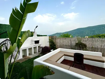a patio with a black chair on top of a building at Sakarya Sapanca Memnuniye de 2 oda 1 salon Özel Havuzlu , Muhafazakar , Şömineli , Jakuzili 6 Kişilik Tatil Villası in Sapanca