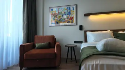 a bedroom with a bed and a chair and a painting at Yıldız Termal Otel in Çekirge İstasyonu