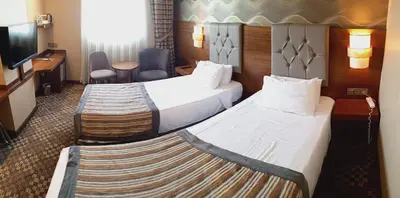 a hotel room with two beds and a television at Adranos Hotel in Bursa