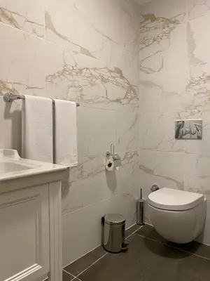 a white bathroom with a toilet and a sink at Ozkaya Apartments Galata in Istanbul