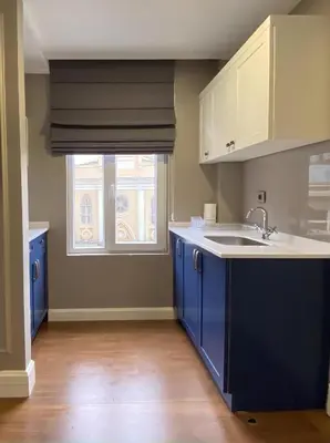 an empty kitchen with blue cabinets and a window at Ozkaya Apartments Galata in Istanbul