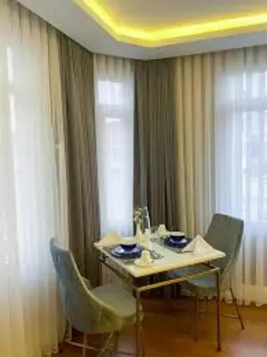 a dining room table with chairs and a table and a window at Ozkaya Apartments Galata in Istanbul