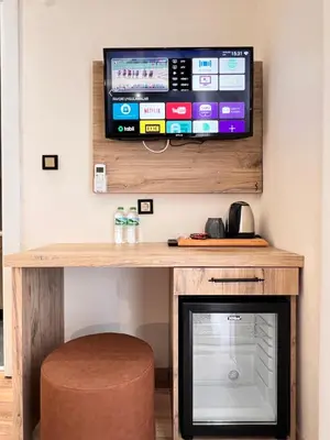 a room with a tv and a stool and a table at The Bail Hotel in Istanbul