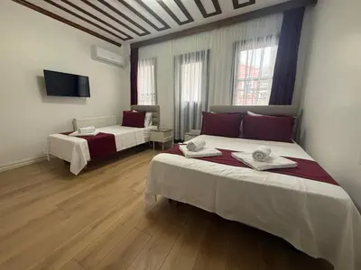 a room with two beds and a flat screen tv at Neo Konak in Istanbul