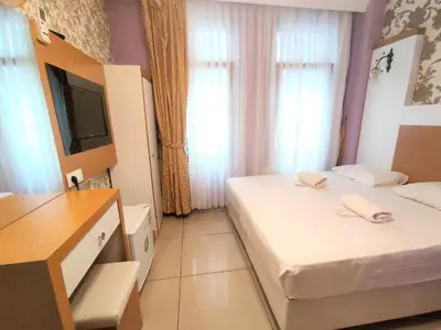 a small room with two beds and a television at Grafen Hotel in Istanbul