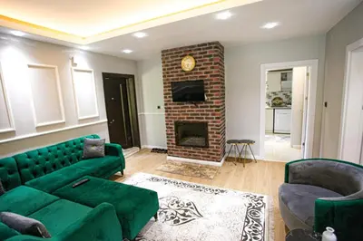 a living room with a green couch and a fireplace at Sakarya Sapanca da Özel Havuzlu , Ailelere Özel Villalar in Sapanca