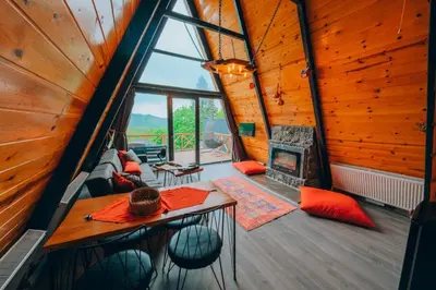 a room with a table and a fireplace in a tree house at Sakarya Sapanca Memnuniye de 3 Oda1 salon Özel Havuzlu-Jakuzili-Şömineli-Korunaklı 8 Kişilik Bungalov in Sapanca