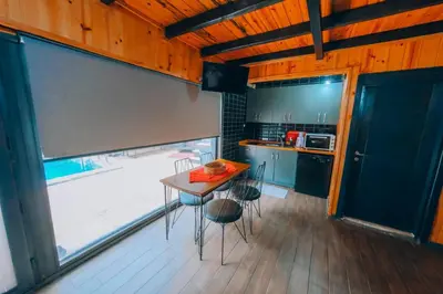 a kitchen with a table and chairs in a room at Sakarya Sapanca Memnuniye de 3 Oda1 salon Özel Havuzlu-Jakuzili-Şömineli-Korunaklı 8 Kişilik Bungalov in Sapanca