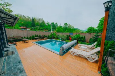 a backyard with a swimming pool and a wooden deck at Sakarya Sapanca Memnuniye de 3 Oda1 salon Özel Havuzlu-Jakuzili-Şömineli-Korunaklı 8 Kişilik Bungalov in Sapanca