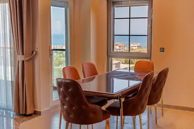 a dining room with a table and chairs and windows at Comfort 4 bedroom villa yalova see view in Yalova