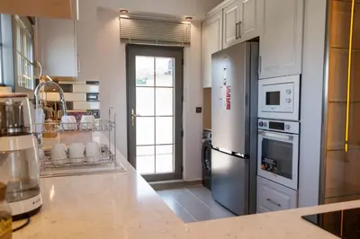 a large kitchen with a refrigerator and a stove at Comfort 4 bedroom villa yalova see view in Yalova