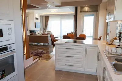 a kitchen with white cabinets and a living room at Comfort 4 bedroom villa yalova see view in Yalova