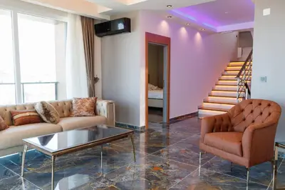 a living room with a couch and a table and stairs at Comfort 4 bedroom villa yalova see view in Yalova