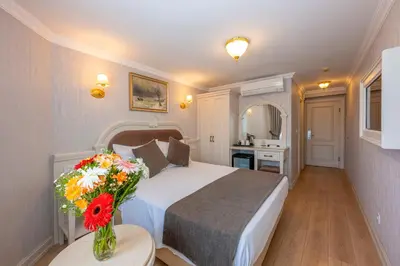 a bedroom with a bed and a vase of flowers on a table at Arden City Hotel-Special Category in Istanbul