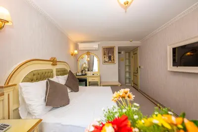 a bedroom with a white bed and a table with flowers at Arden City Hotel-Special Category in Istanbul